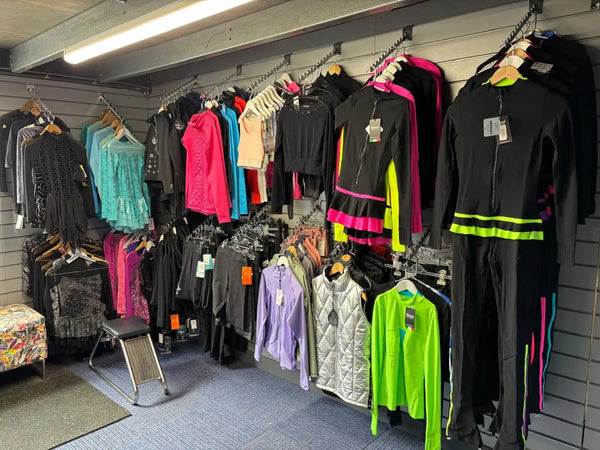 Black athletic tracksuit with neon green and pink accent stripes.