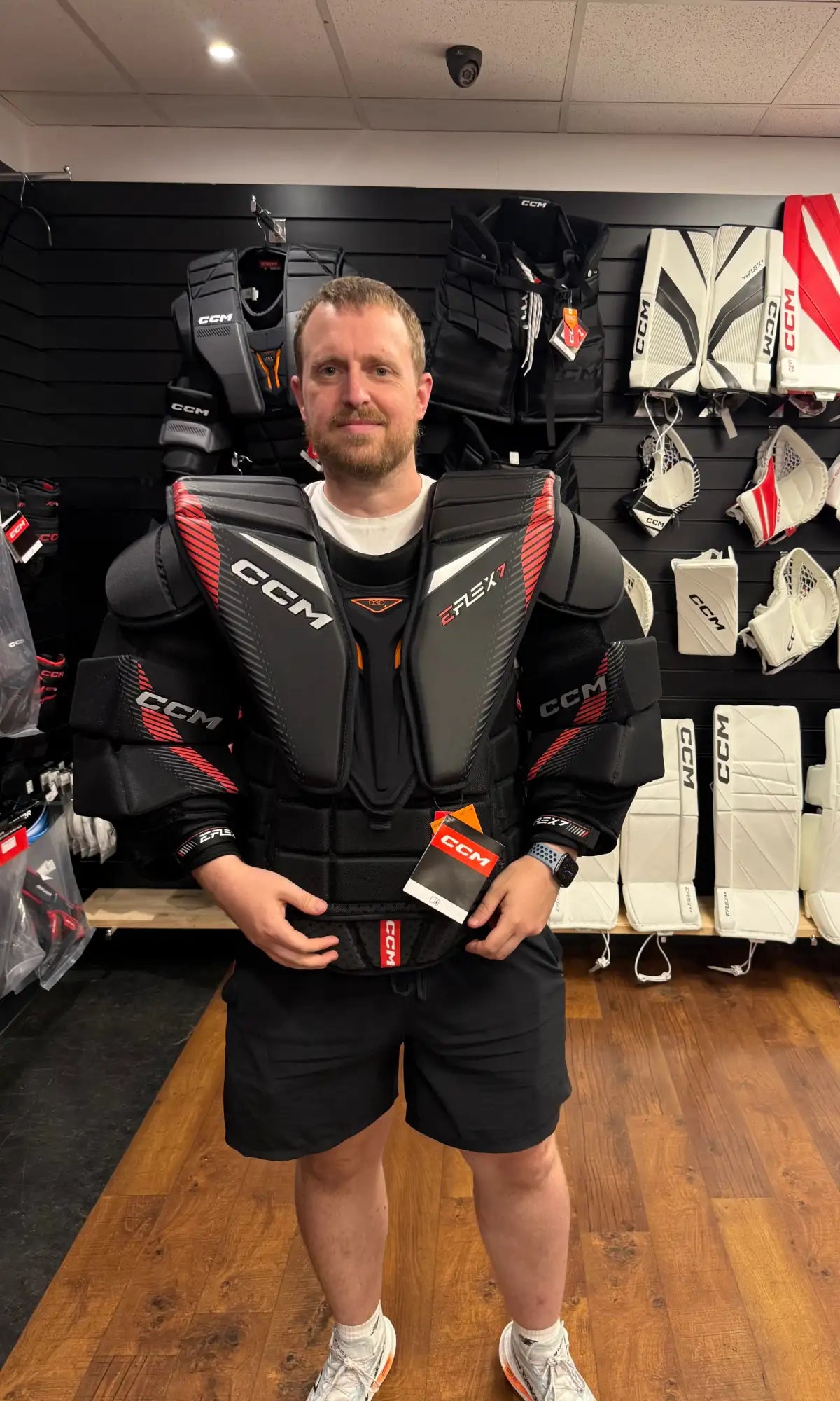 Black and red ccm e-rex7 hockey shoulder pads with a sleek, protective design.