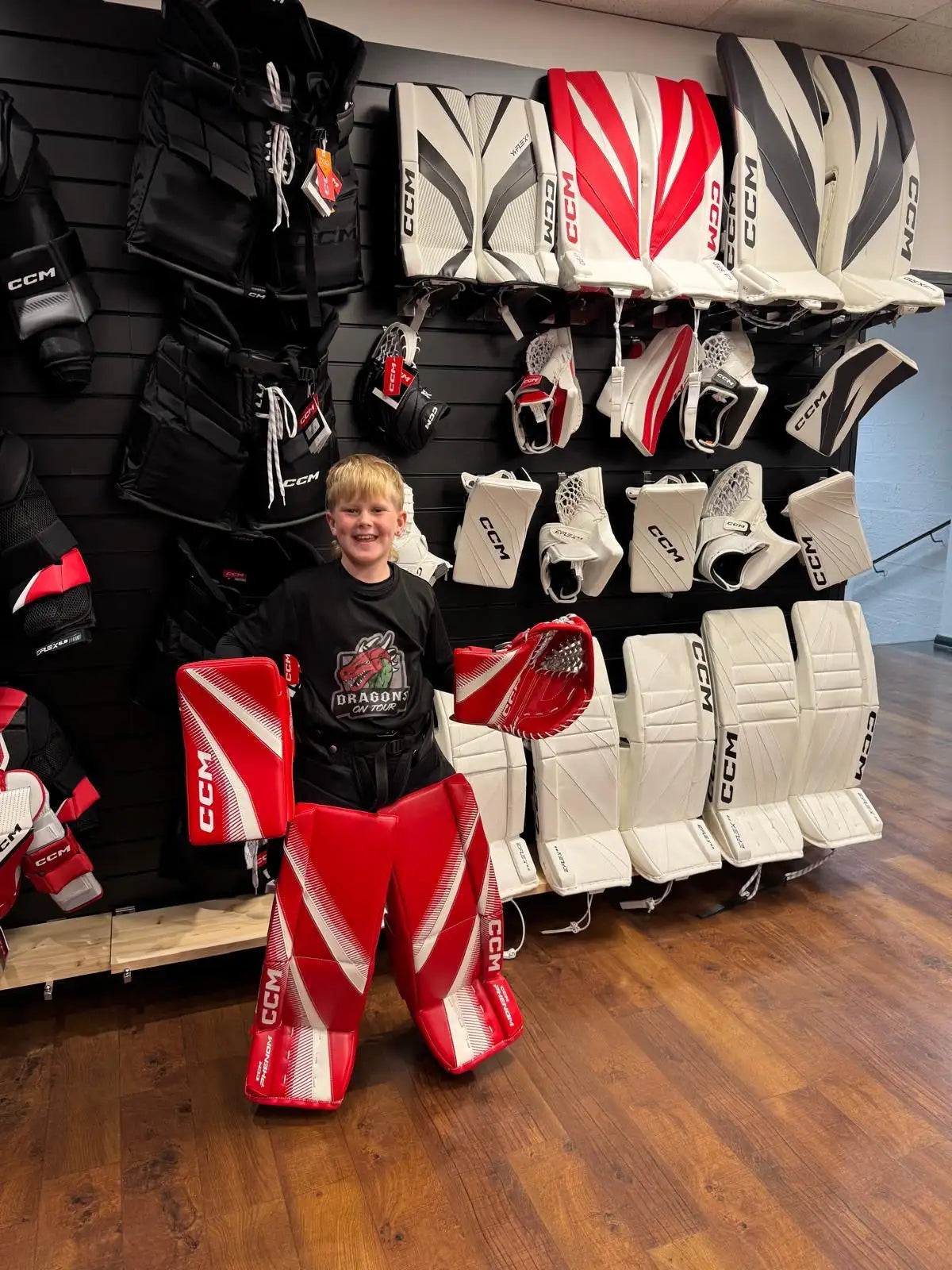 Red and white ccm goalie pads with black accents