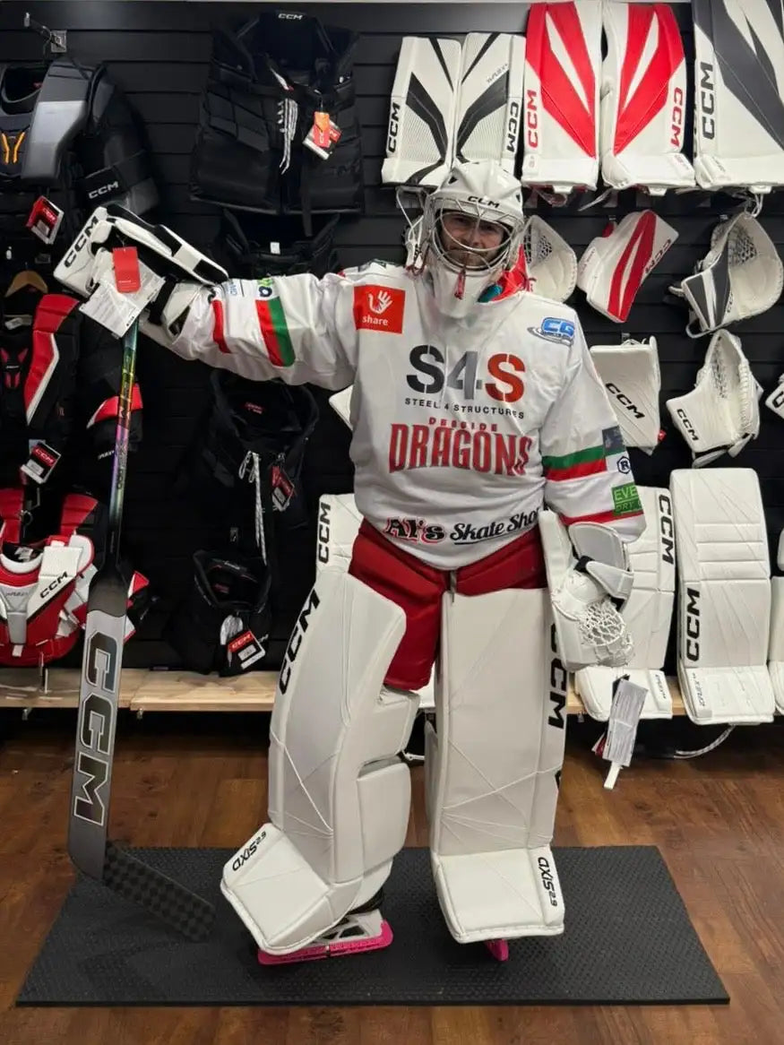 White ccm hockey goalie gear set with red and green accents, featuring ’s4s dragons’ branding on the jersey.